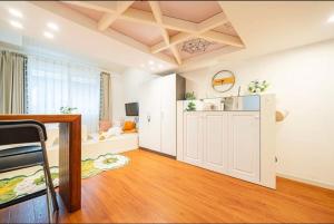 una gran sala de estar con paredes blancas y suelos de madera. en Shanghai Hills & Well-time Homestay Yuyuan en Shanghái