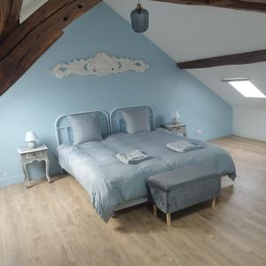a bedroom with a blue bed with a ottoman at Spacieux duplex en plein centre-ville de Fontainebleau in Fontainebleau +35 photos