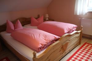 クアオルト・オーバーヴィーゼンタールにあるAppartementhaus am Fichtelbergのベッドルーム1室(ピンクの枕が付くベッド2台付)