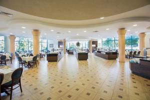 a dining room with tables and chairs and windows at Marina Grand Beach Hotel - All Inclusive Plus in Golden Sands