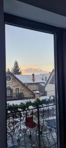 een uitzicht vanuit een raam van een huis met sneeuw bij Casa Pe Vale in Rîşnov