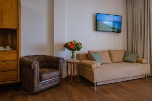 sala de estar con sofá y silla en Grand Large - cosy studio en Papeete