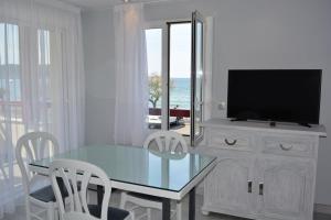 ein Esszimmer mit einem Tisch und einem TV auf einem Schrank in der Unterkunft Résidence ITXASOA - Appartements, plage d'Hendaye in Hendaye