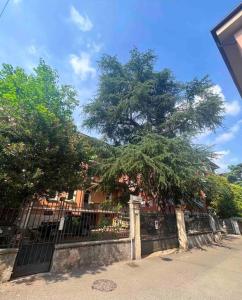 een hek met een grote boom erachter bij LA MANSARDA Modern House in Verona