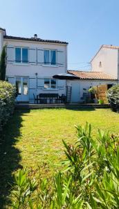 a white house with a lawn in front of it at Maison paisible in Niort