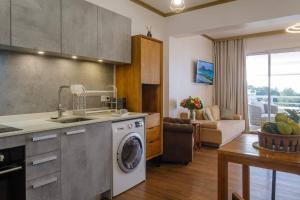 cocina y sala de estar con lavadora en Grand Large - cosy studio en Papeete