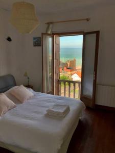 a bedroom with a bed with a view of the ocean at L'Eglantine bord de mer in Ault