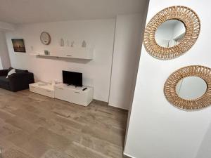 Biały salon z lustrem i telewizorem w obiekcie Apartamento Empul La Barrosa w mieście Chiclana de la Frontera