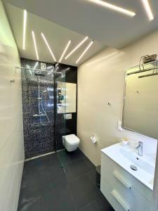 uma casa de banho com um chuveiro, um WC e um lavatório. em Apartament Everest by Managerent em Ustka