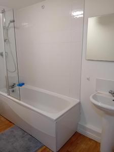 baño blanco con ducha y lavamanos en Apartment closer to the city centre en Mánchester
