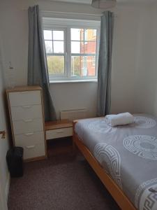 1 dormitorio con cama y ventana en Apartment closer to the city centre en Mánchester