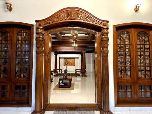 uma porta ornamentada para um quarto com portas de madeira em Dream Palace em Alappuzha