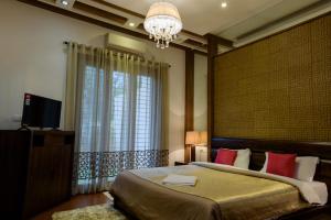 a bedroom with a large bed and a chandelier at Swiss Royal Suites in Bangalore