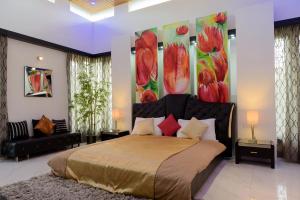 a bedroom with a large bed with a painting on the wall at Swiss Royal Suites in Bangalore