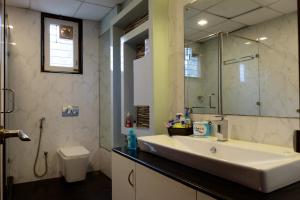 バンガロールにあるSwiss Royal Suitesの洗面台、鏡、トイレ付きのバスルーム +8枚の写真
