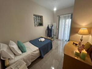 a bedroom with a bed and a table with a lamp at Emyria-Ground Floor Apartment in Zakynthos Town