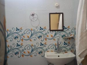 ein Bad mit einem Waschbecken und einem Spiegel in der Unterkunft Leela Hatha in Rishikesh