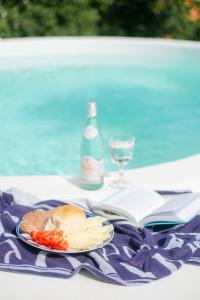 a table with a plate of food and a bottle of wine at PAVI APARTMENTS Life Style House with private pool in Kornić