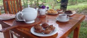 a wooden table with cups and plates of pastries at WILAPTTU WILD VILLA in Pahala Maragahawewa