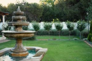 a fountain in the middle of a garden at Lemon & Lime Guesthouse in Bloemfontein