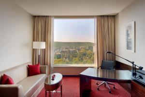 a living room with a couch and a desk and a window at JW Marriott Pune in Pune