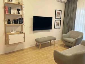 sala de estar con silla y TV en Downtown Apartment en Kavala