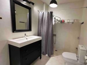 y baño con lavabo, aseo y espejo. en Downtown Apartment en Kavala