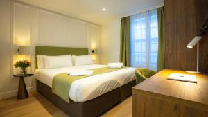 una camera d'albergo con un grande letto e una finestra di Casa Pince a Barcellona