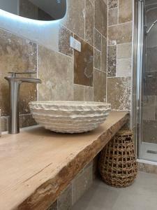 uma casa de banho com um lavatório num balcão de madeira em Le Charmeur * * * em Aurillac