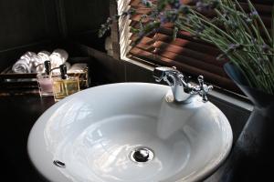 un lavandino bianco in un bagno con uno specchio di Lemon & Lime Guesthouse a Bloemfontein