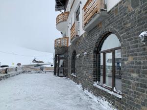 a building with snow on the ground next to a building at Hotel Dia Lin in Borşa +21 photos