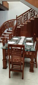 uma mesa e cadeiras de madeira com uma tampa de vidro em Dream Palace em Alappuzha