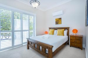 a bedroom with a bed and a large window at Dory's Beach House - Executive Escapes in Safety Bay