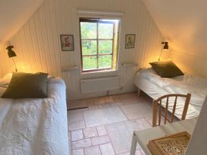 Cette petite chambre comprend 2 lits et une fenêtre. dans l'établissement Sövröds Hage, à Höör