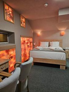 a bedroom with a bed and a table and chairs at Fantastico Exlcusive Hotel in Senta