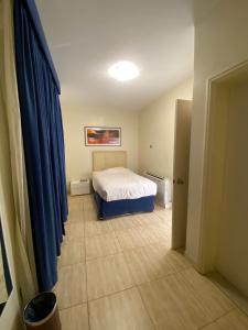 1 dormitorio con cama y cortina azul en Dana Beach Resort منتجع شاطئ الدانة, en Bahía de la Media Luna