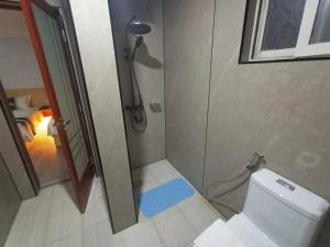 a bathroom with a shower and a toilet with a blue rug at Venice Star Grand Hotel in Manila