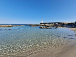 a beach with a lighthouse in the distance at Meraviglia d'Otranto in Otranto