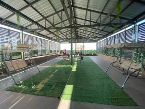 un gran edificio con un suelo verde con mesas y sillas en Melon Hub ใกล้สนามบินสุวรรณภูมิ, en Ban Bang Toei (1)