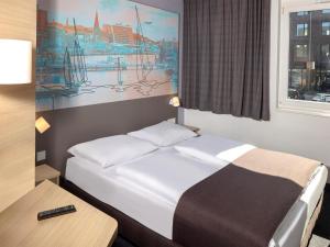 a hotel room with a bed and a window at B&B Hotel Kiel-City in Kiel