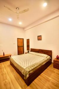 a bedroom with a bed and a wooden floor at The Flying Squirrel Bandhavgarh in Umariā