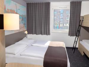 キールにあるB&B Hotel Kiel-Cityのベッド2台と窓が備わるホテルルームです。