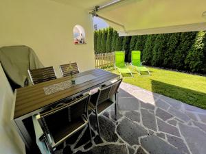 a patio with a table and chairs and a lawn at Moida-Ferienwohnung in Fügen