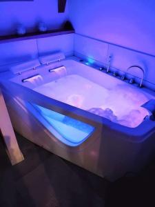 a hot tub with blue lights in a room at Gîte du Milan royal in Le Monteil