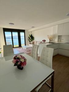 una cocina y una sala de estar con una mesa con flores. en El Mirador Ría de Vigo, apartamento frente al mar, céntrico, en Moaña