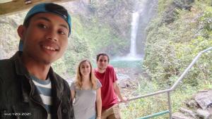 a group of people standing in front of a waterfall at Las vegas lodge and restaurant in Banaue