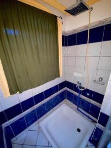 La salle de bains est pourvue d'une baignoire et d'un rideau vert. dans l'établissement Das Traum Guest Haus, à Siquijor