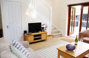 a living room with a tv on a wooden table at Middledown in Alton