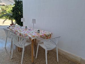 a table with white chairs and a table cloth on it at Meraviglia d'Otranto in Otranto