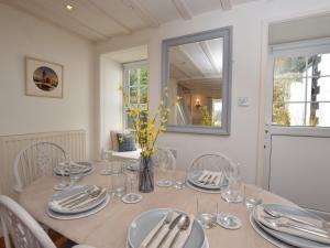 - une table à manger avec des assiettes et des verres dans l'établissement 3 Bed in Conwy TYGOS, à Llangelynin